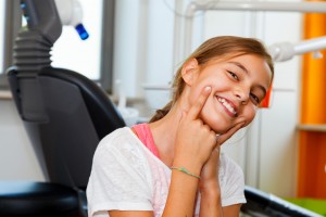 Funny and happy little girl in a dental surgery with big smile.